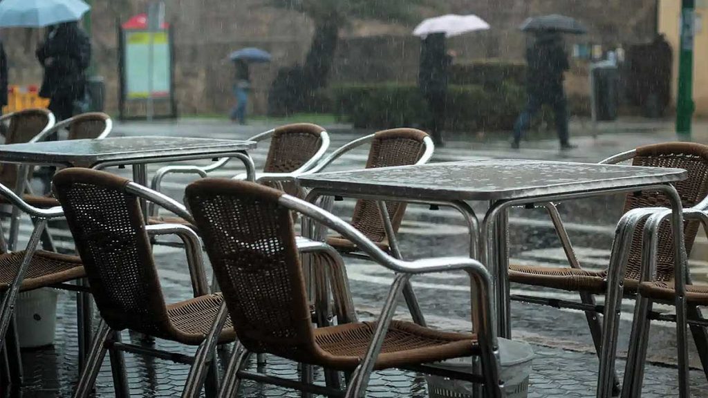 Veladores de un restaurante bajo la lluvia.