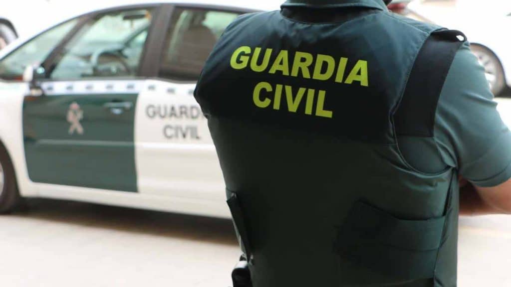 Guardia Civil junto a coche patrulla.