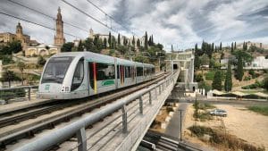 Vagón de metro de Sevilla con el Aljarafe al fondo con el monumento a un lado.
