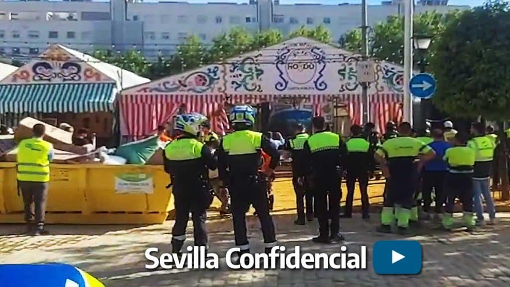 Bomberos y policías locales ante la caseta que se incendió.