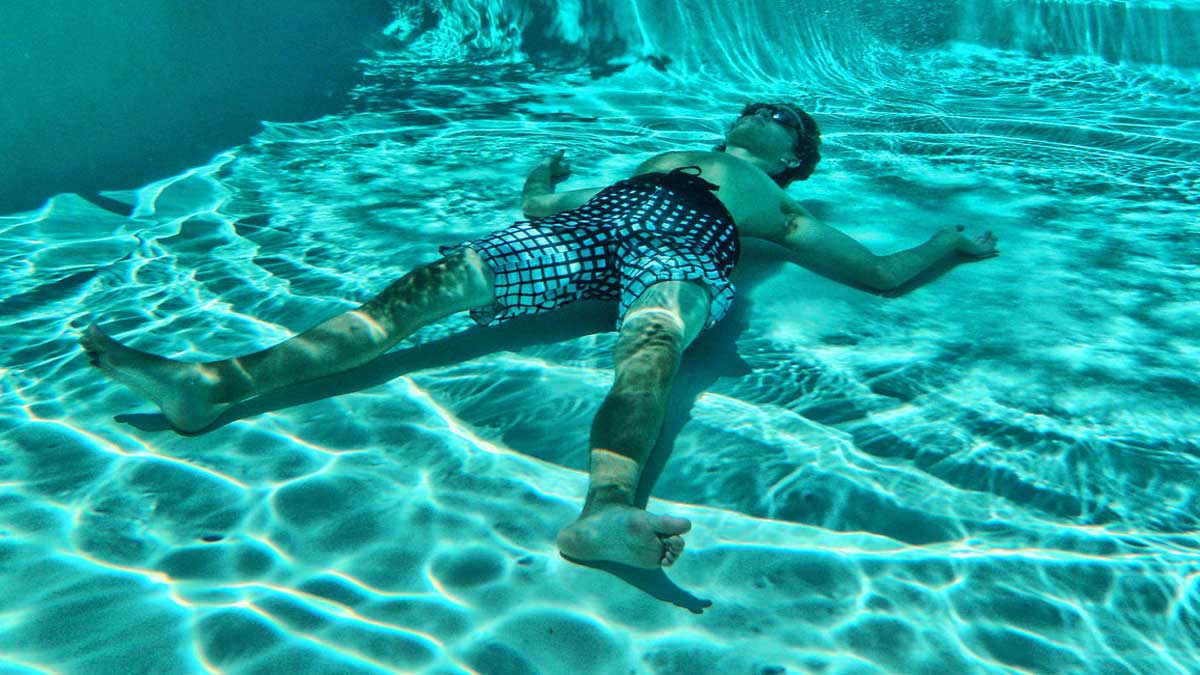 Persona simulando un ahogamiento en una piscina.