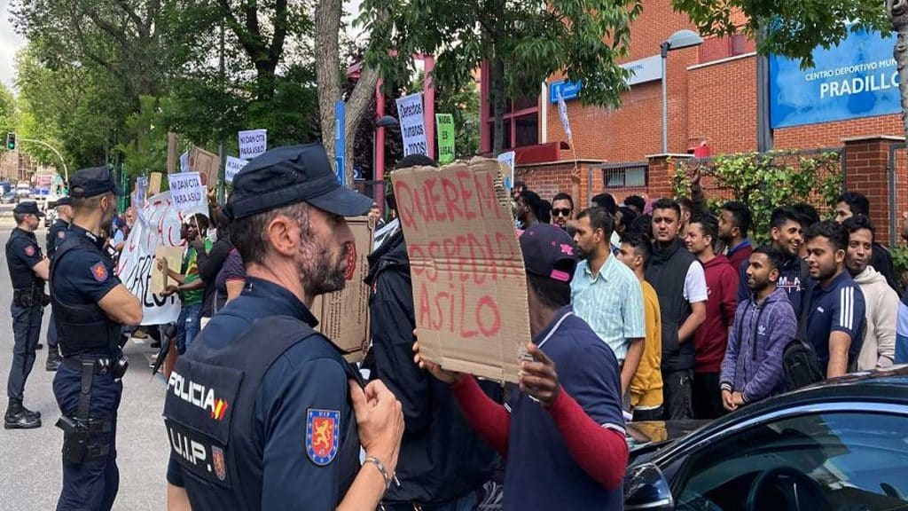 Policía vigilando a un grupo de migrantes.