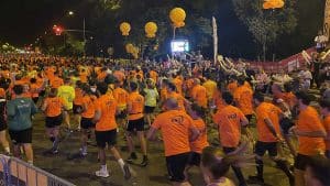 Corredores y las camisetas naranja de la Carrera Nocturna de Sevilla.