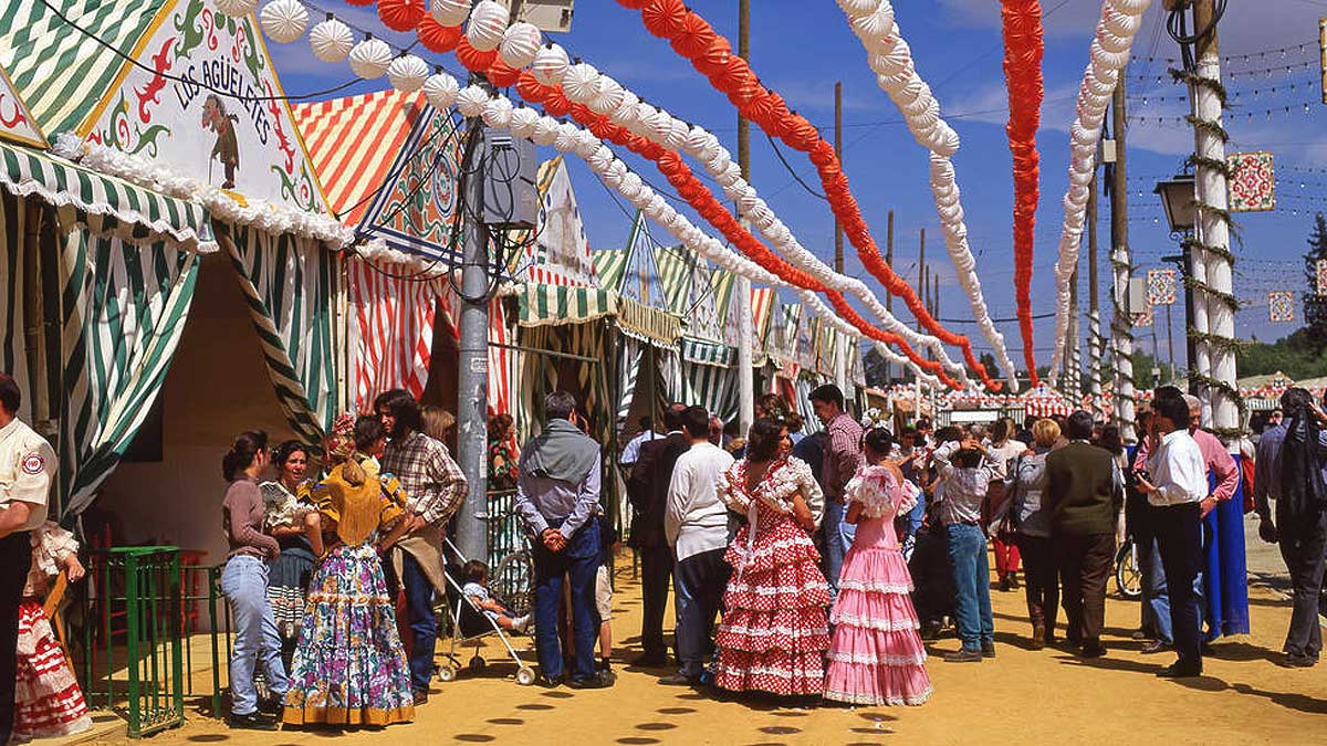 Personas en la puerta de una caseta en una calle de la Feria de Sevilla.