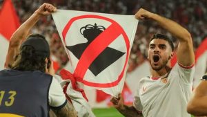 El jugador Isaac Romero con una pancarta que atenta a los símbolos verdiblancos.