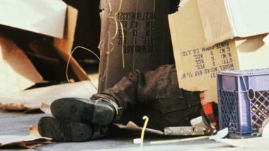 Mendigo durmiendo entre cartones.