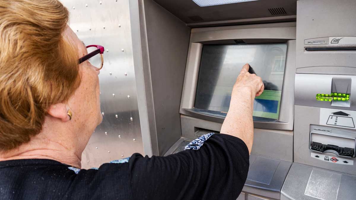 Mujer sacando dinero de un cajero.