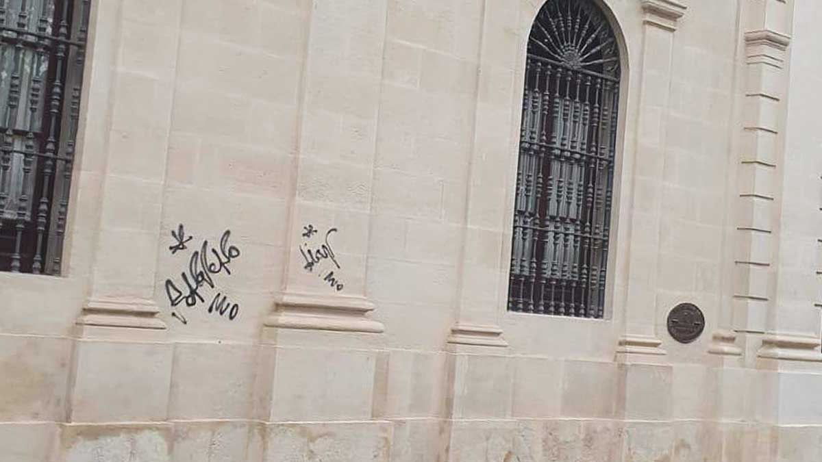La fachada del ayuntamiento de Sevilla con las pintadas en negro realizada por los vándalos.