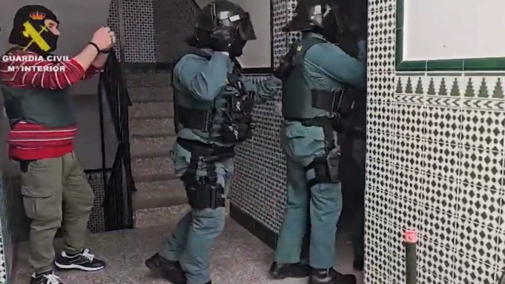 Tres agentes de la Guardia Civil fuerzan la entrada para acceder a un narcopiso.