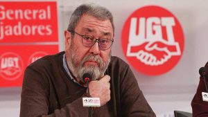 Cándido Méndez sentado y tras él la publicidad de UGT en rojo y blanco.