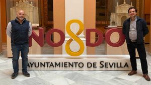 Miembros del Foro Fernando III junto al escudo de Sevilla, el NO&DO.