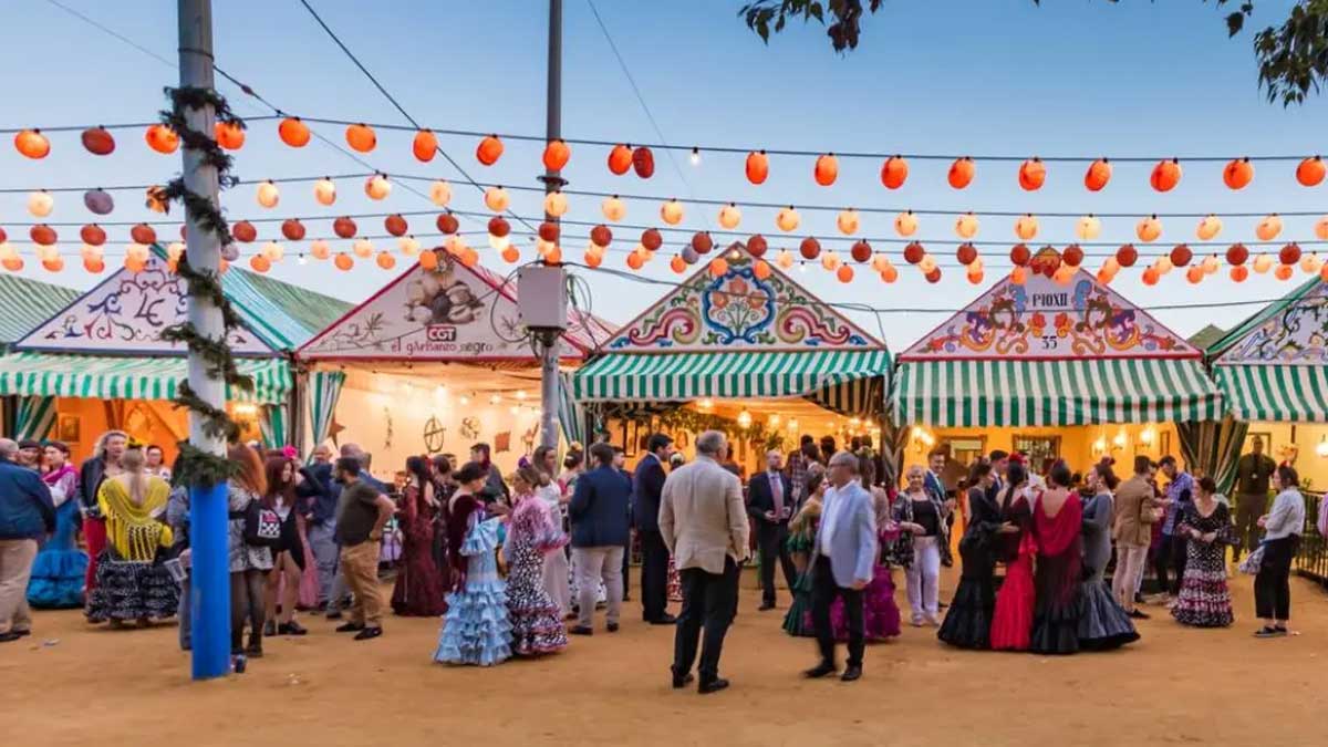 Casetas de Feria con personas en la calle charlando y bailando.