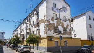 Edificio en blanco con partes en ladrillo visto por el deterioro en Los Pajaritos.