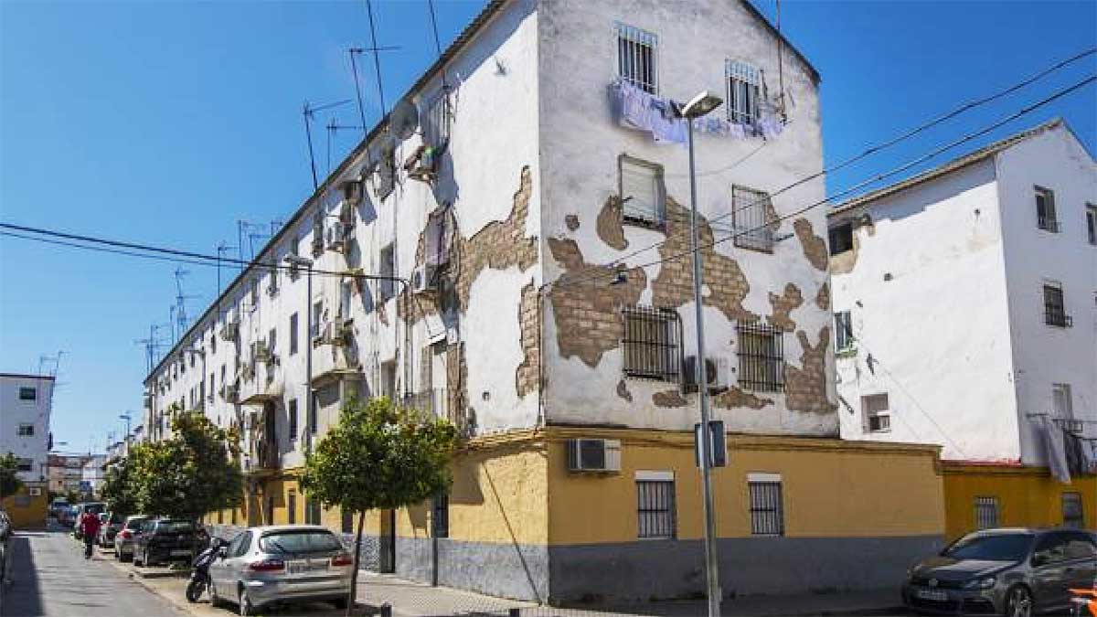 Edificio en blanco con partes en ladrillo visto por el deterioro en Los Pajaritos.