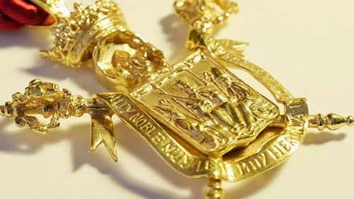 Medalla dorada de la ciudad de Sevilla en la que destaca el escudo con el rey San Fernando.