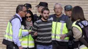 Miguel Carcaño con camiseta de rayas saliendo de los Juzgados custodiado por la Policía.