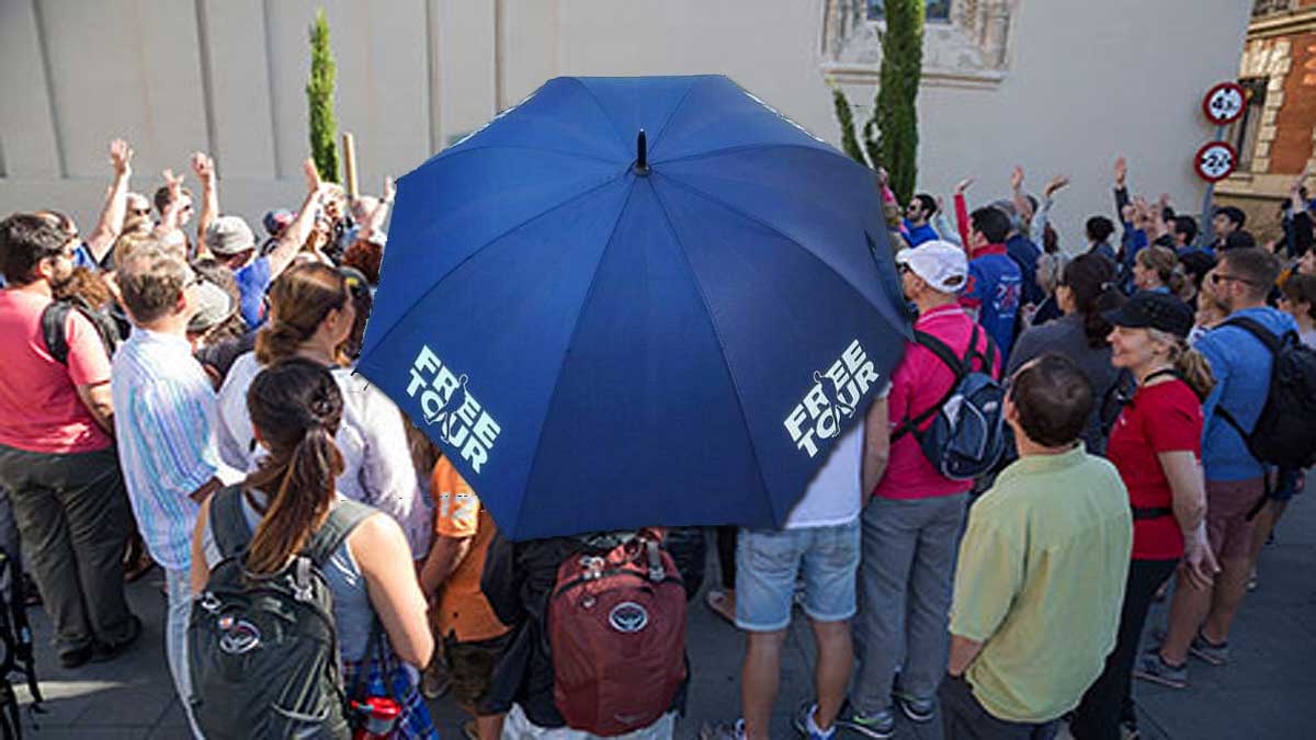 Grupo de personas y un paraguas azul de un freetour.