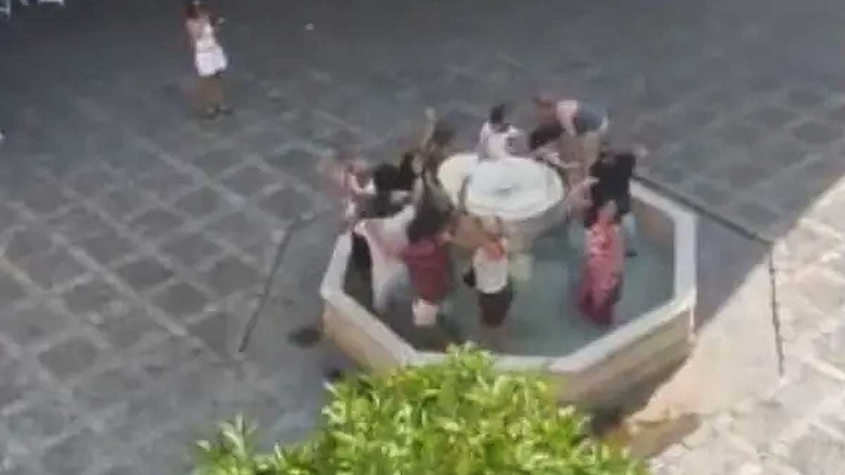 Turistas metidos dentro de una fuente en el barrio de Santa Cruz.