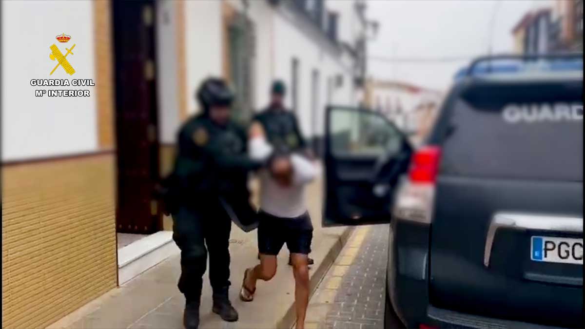 El prófugo esposado, con las manos a la espalda, siendo introducido en un automóvil de la Guardia Civil.