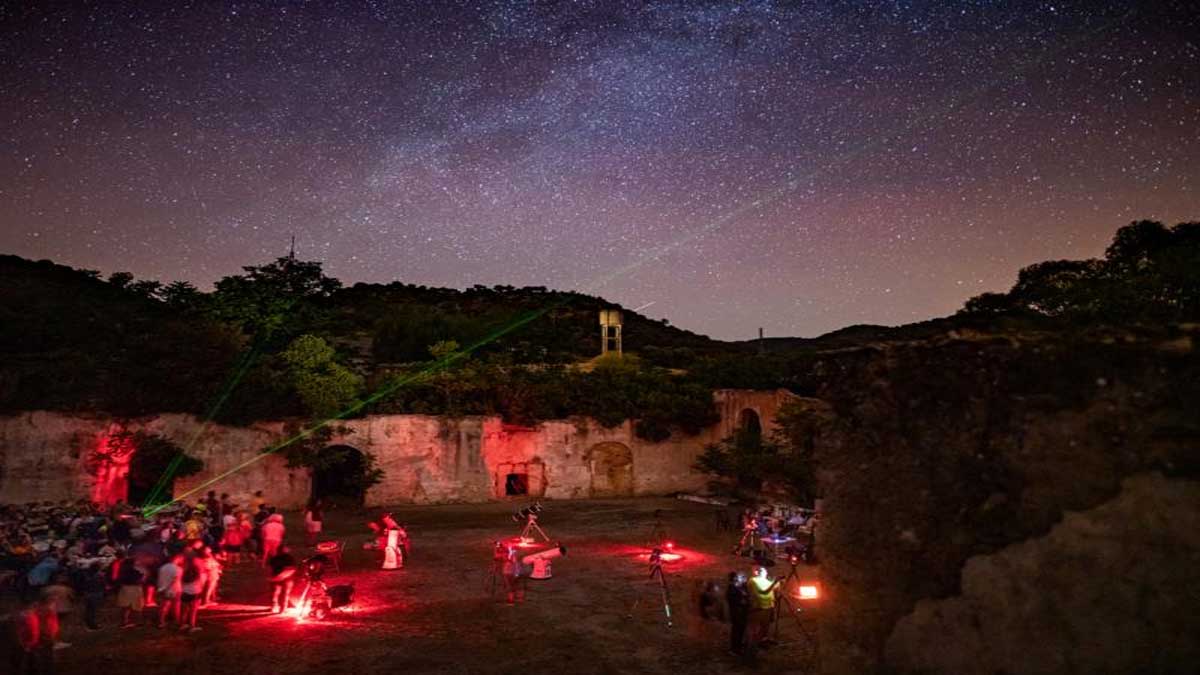 Reunión de personas en El Pedroso, en la noche, con el cielo estrellado.