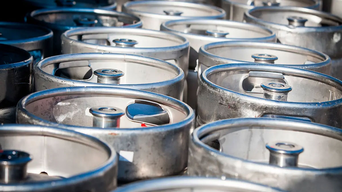 Barriles de cerveza metálicos en un almacén.