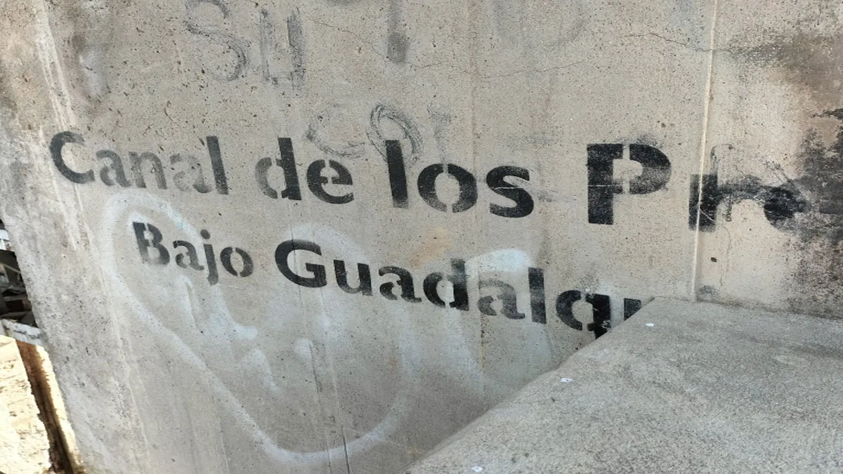 Muro de cemento con el letrero en negro de "Canal de los Presos".
