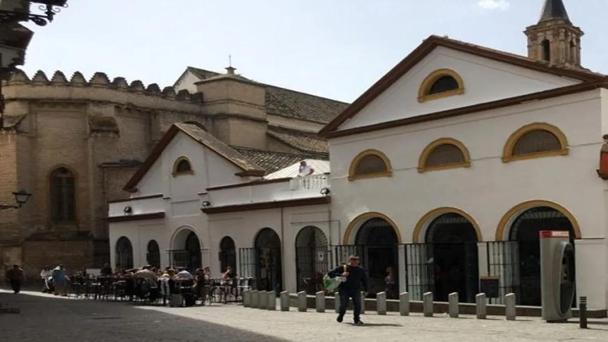 Acceso trasero del Mercado de Feria, encalado en blanco junto a la torre de la iglesia.