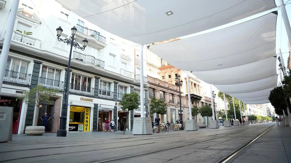 Postes y toldos sobre el asfalto de la Avenida de la Constitución.