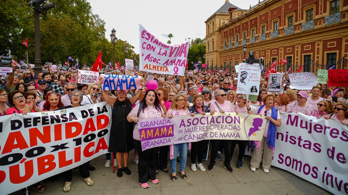 Mujeres con pancartas manifestándose por los errores en el cribado del cáncer de mama.