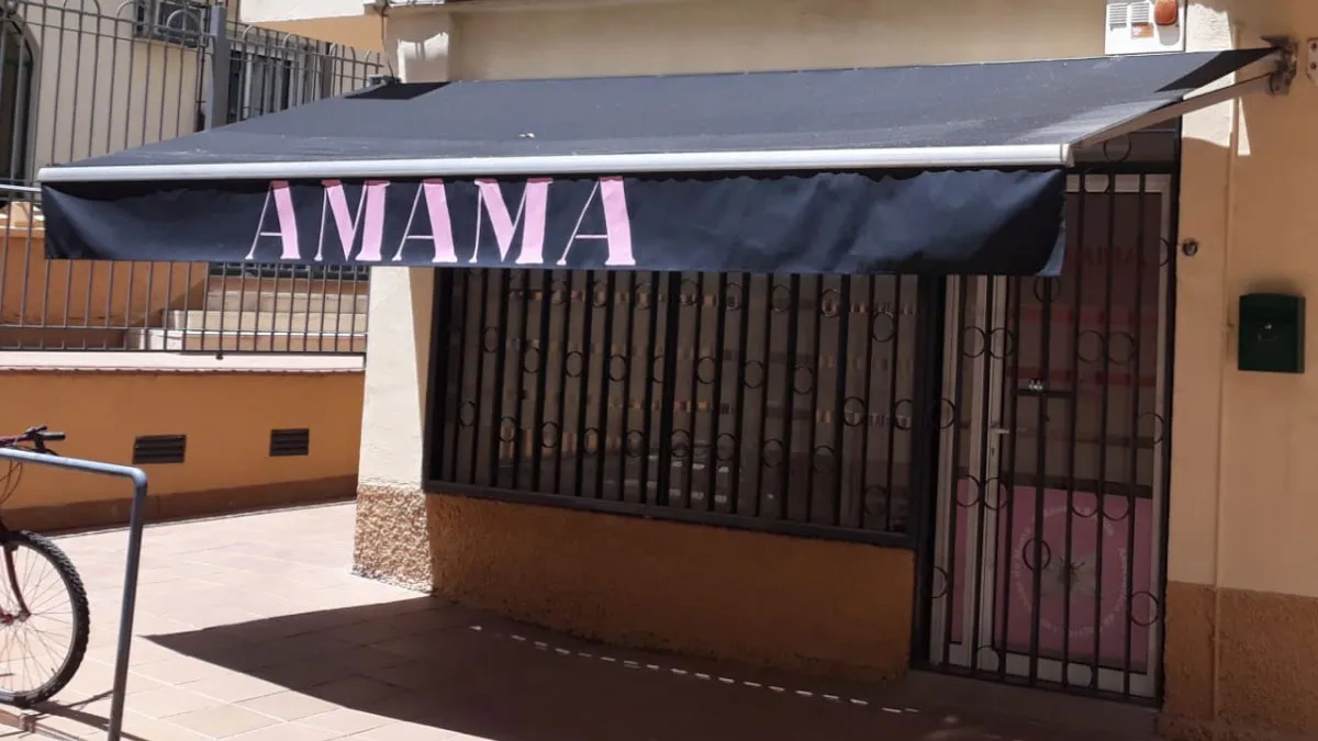Puerta de acceso y toldo con el nombre de Amama.