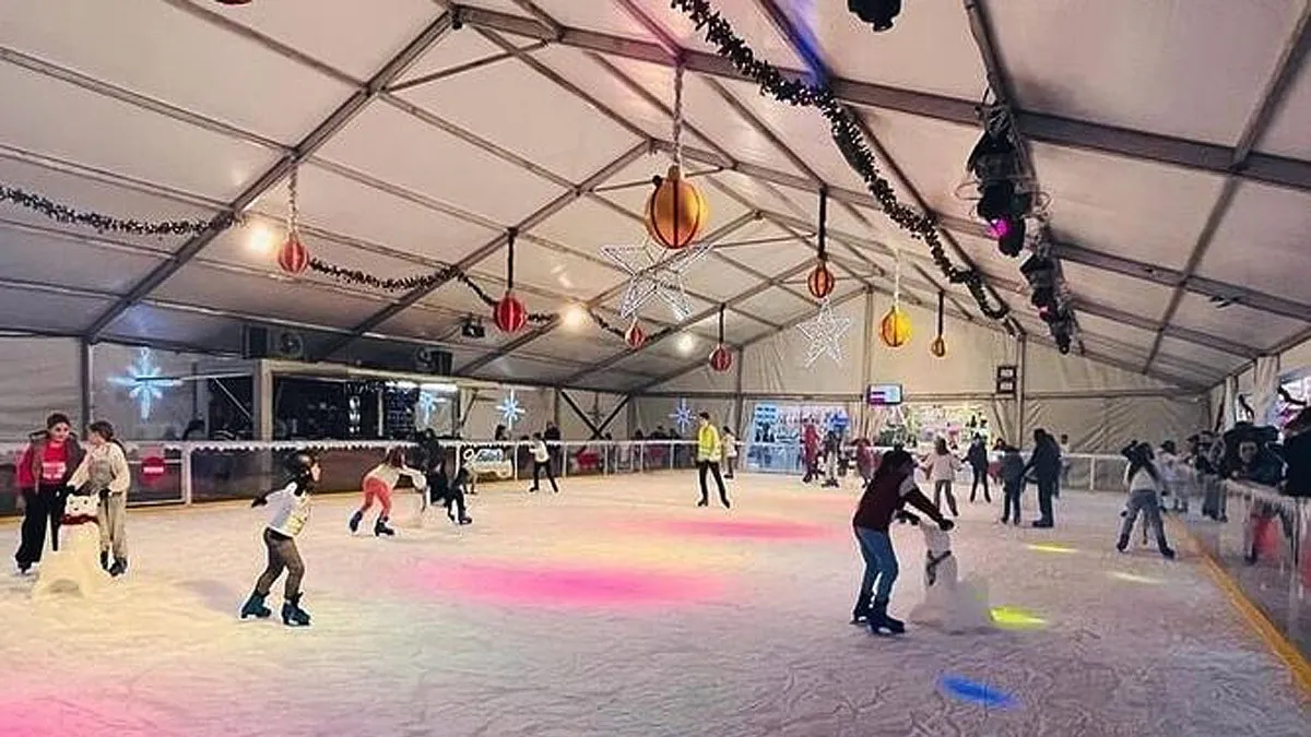 Muchas personas que patinan la pista de hielo de Navidad Park.