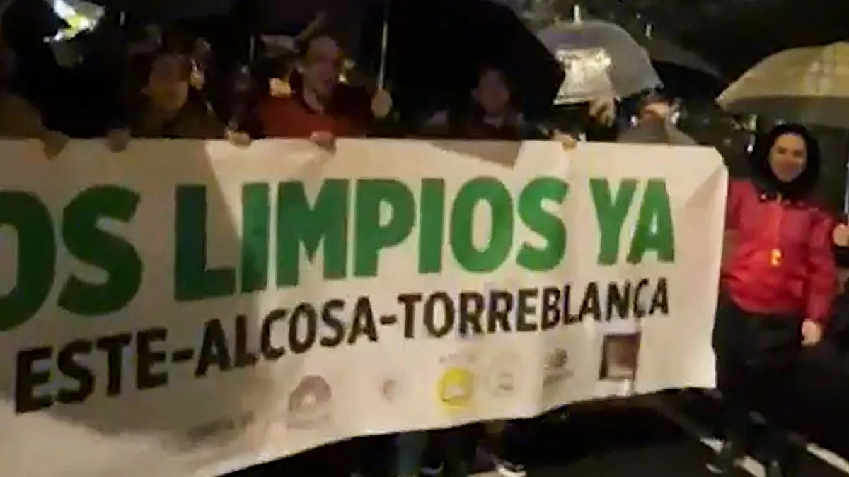 Vecinos portando una pancarta pidiendo limpieza en los colegios de Sevilla Este.