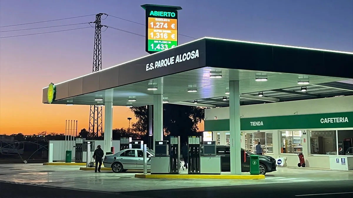Gasolinera de Alcosa con diferentes coches repostando al atardecer.