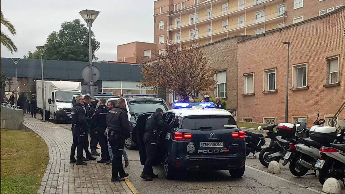 Diferentes coches y policías nacionales en la puerta de acceso al hospital Virgen del Rocío.