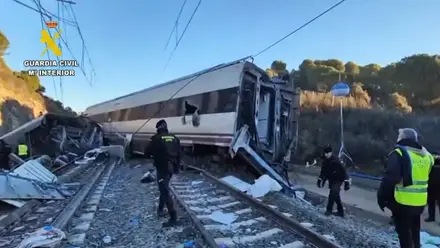 Vagones de tren volcados y agentes de la Guardia Civil.