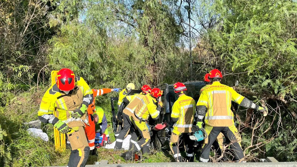 Grupo de bomberos alrededor del coche accidentado.