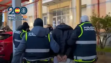 Policía con delincuente esposado entrando en comisaría.