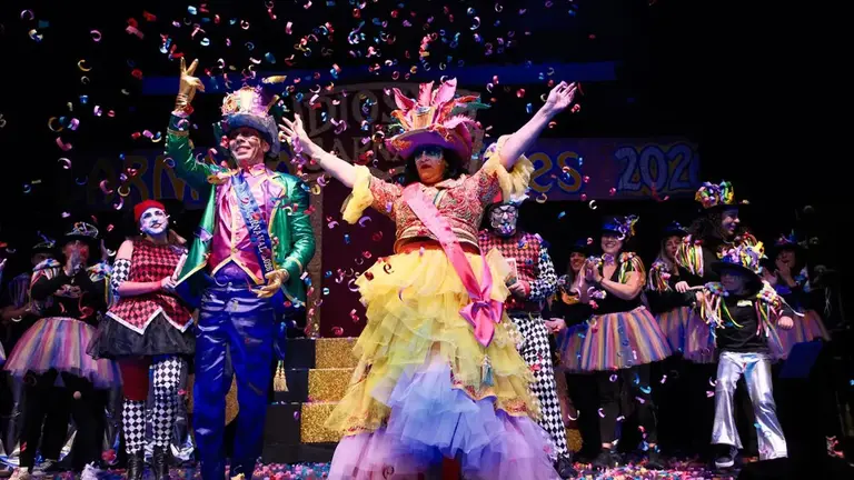 Personas disfrazadas y papelillos cayendo.