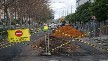 Señal de obras en carretera auxiliar y maquinaria.