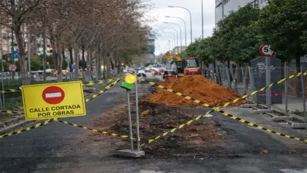 Señal de obras en carretera auxiliar y maquinaria.