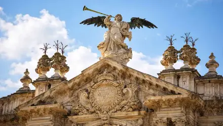 Remate del frontón de la Puerta de la Universidad de Sevilla, arriba la Estatua de la Fama.