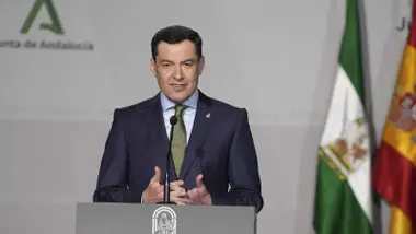 El presidente de la Junta de Andalucía, en un atril con las banderas tras él.