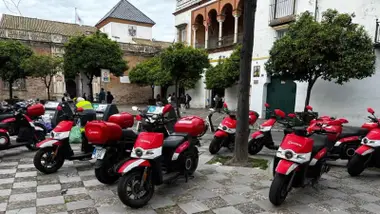 Motos rojas y blancas de Acciona en el acerado.