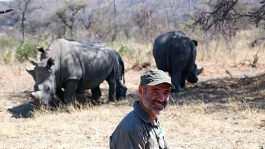 Dani Serralta y unos rinocerontes tras él.