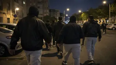 Grupo de hombres con pasamontañas patrullan su barrio contra los gorrillas en una calle de El Cerezo.