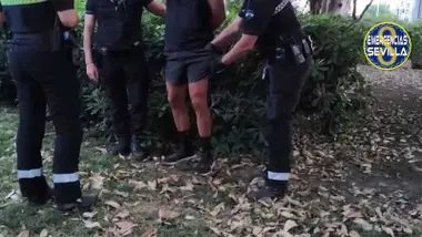 Momento de la detención en el que dos policías locales esposan y registran al exhibicionista.