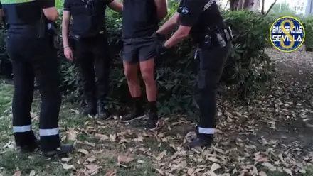 Momento de la detención en el que dos policías locales esposan y registran al exhibicionista.