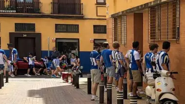 Varios hombres con la camiseta de la Real Sociedad orinando en una calle de Sevilla.