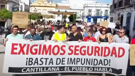 Protesta de los vecinos que portan una pancarta contra la inseguridad en Cantillana.