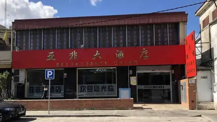 Fachada roja con letras doradas de un restaurante chino en Sevilla.